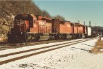 Three EMD's power an manifest west out of the yard